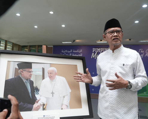 Haedar Nashir (Ketua Umum PP Muhammadiyah) berdiri dihadapan sebuah foto yang memuat gambar pertemuan Pertemuan Ketua Umum PP Muhammadiyah dengan Paus Fransisku di Vatikan pada 24 Februari 2024 dalam rangka menerima Zayed Award for Human Fraternity.